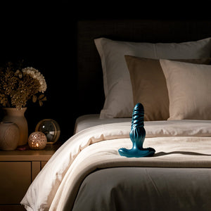 Blue object on a bed with a dark background