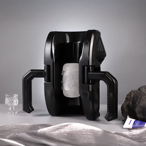 Black male sex stroker on a gray surface with a glass and rock in the background