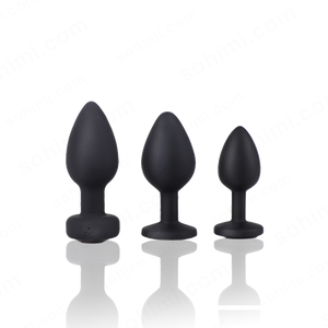 Three black silicone butt plugs of different sizes on a white background