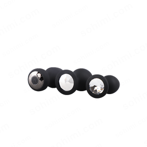 Set of black butt plug with metallic and crystal accents on a white background