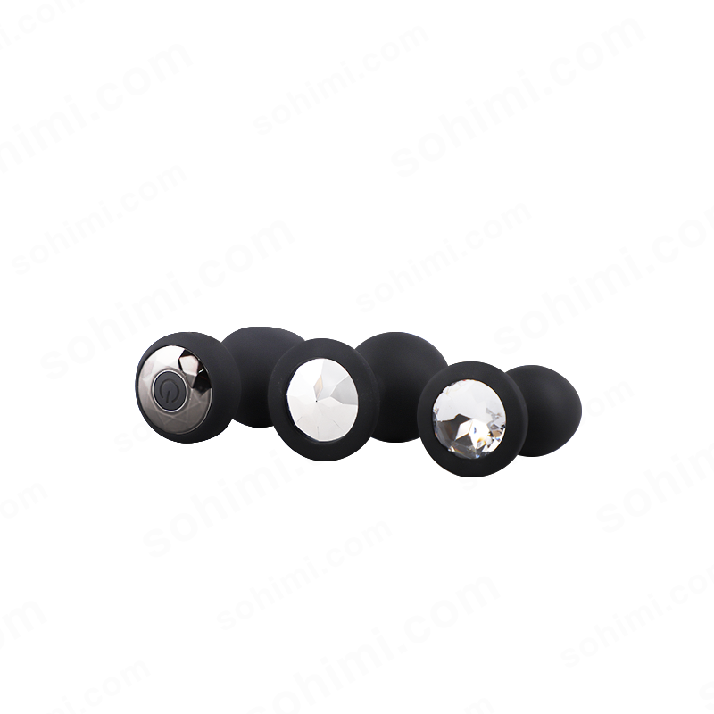 Set of black butt plug with metallic and crystal accents on a white background